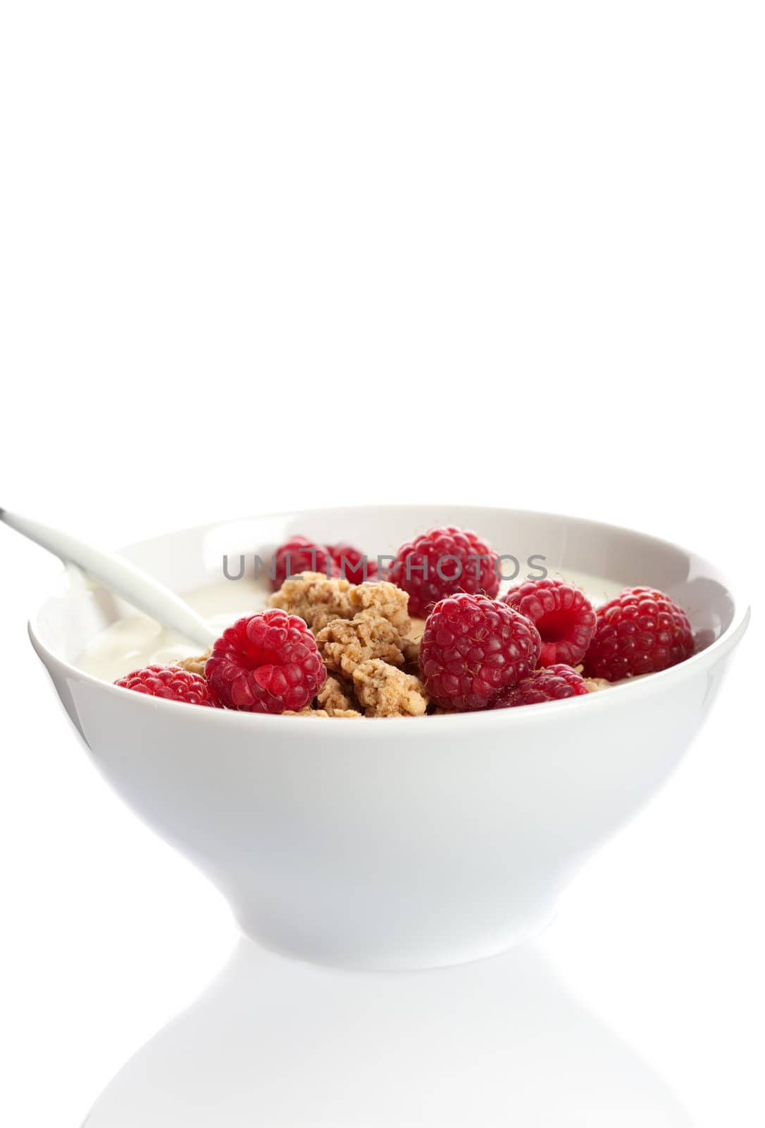 Small bowl filled with vanilla yogurt, raspberries and cruesli