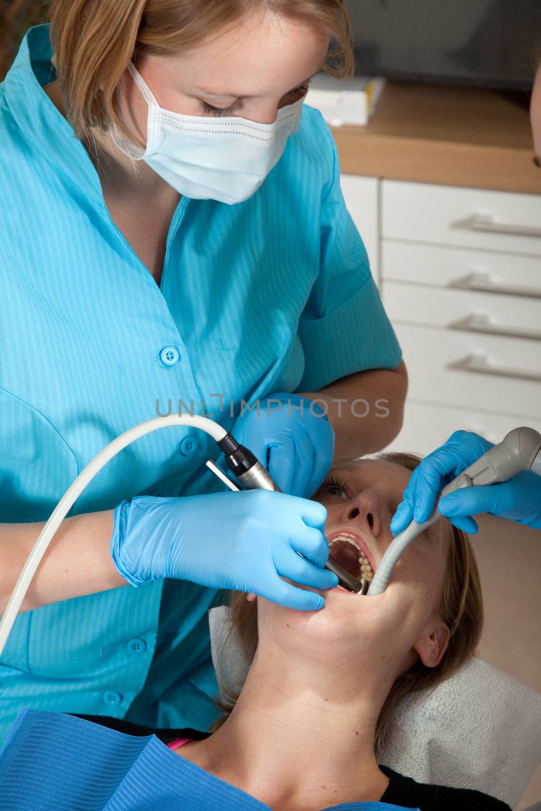 Female dentist drilling a cavity in her patients mouth