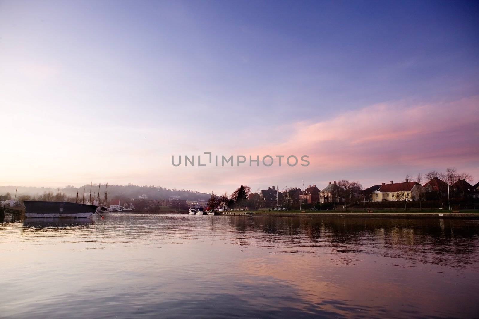 A boat harbor in the late fall painted in the evening light of sunset