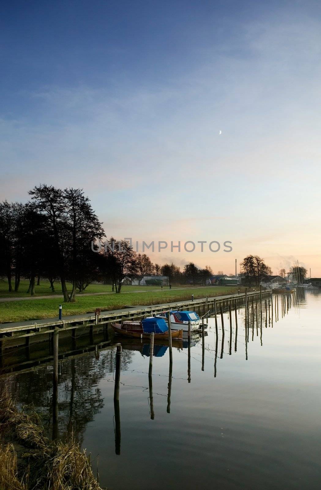 A boat harbor in the late fall painted in the evening light of sunset