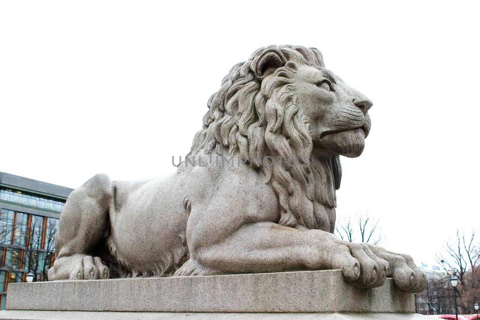 A lion statue sits majesticaly on it's pedestal.