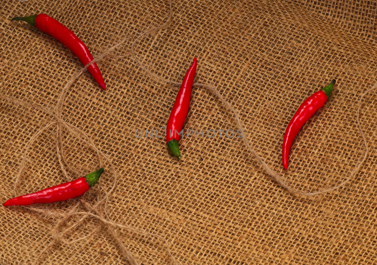 Four red hot chilli pepper on a sacking