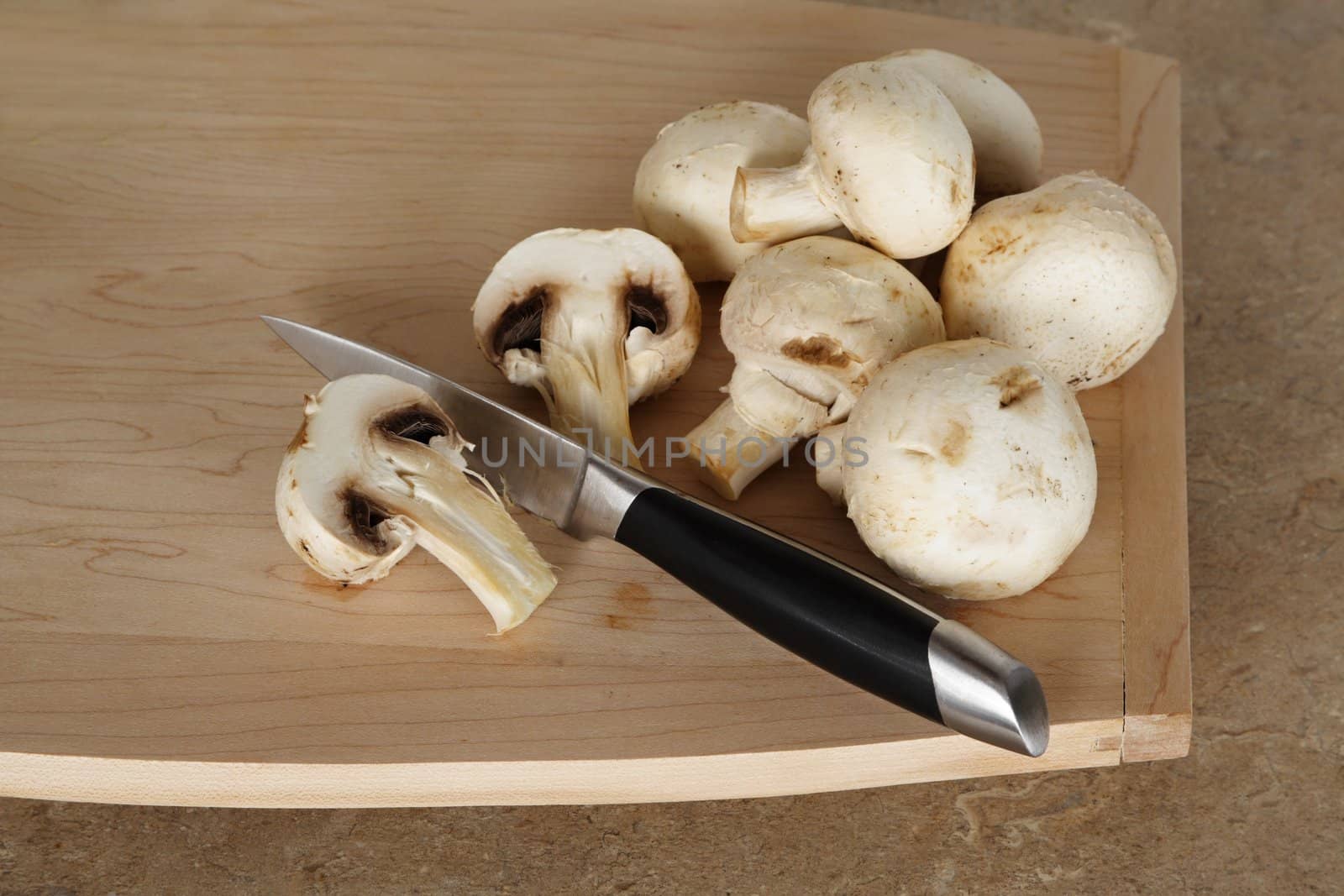 mushroom with knige on wood cutting board
