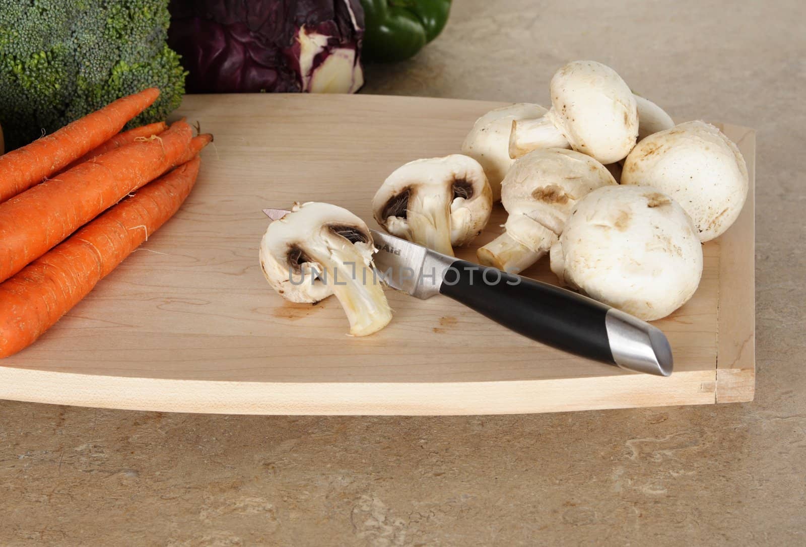 mushroom on wood cutting board, with some other vegetable on background