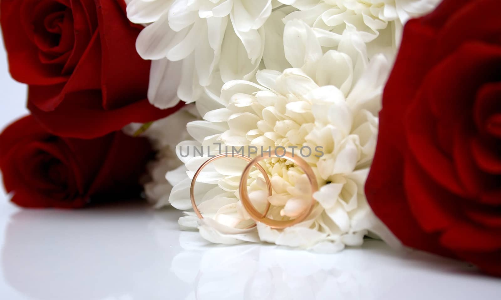 wedding rings, red roses and white chrysanthemumon. Shallow DOF