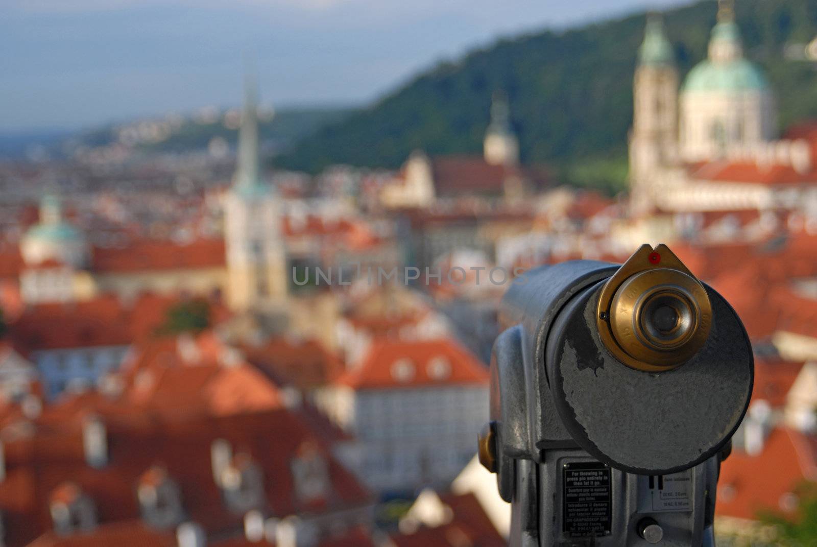 Old telescope and landscape of Prague out of focus behind