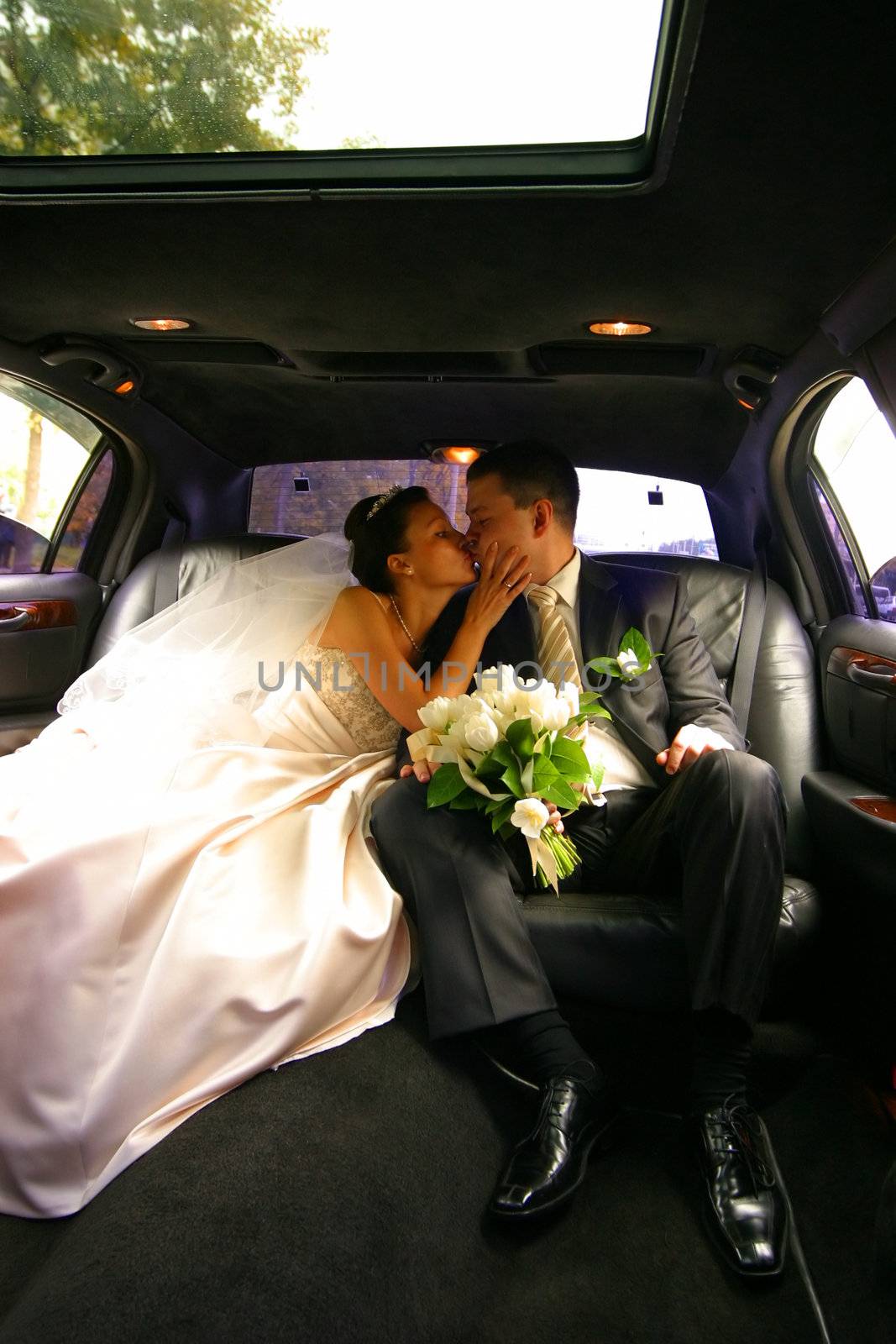 Kiss of a newly-married couple in car
