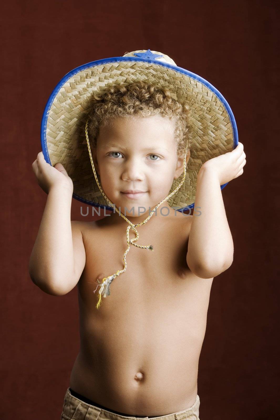 Little boy with curly hair and blue eyes in a sheriff hat