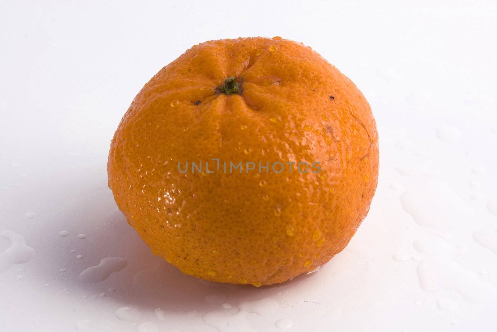 Juicy tangerine covered by drops of water. Isolated on white background
