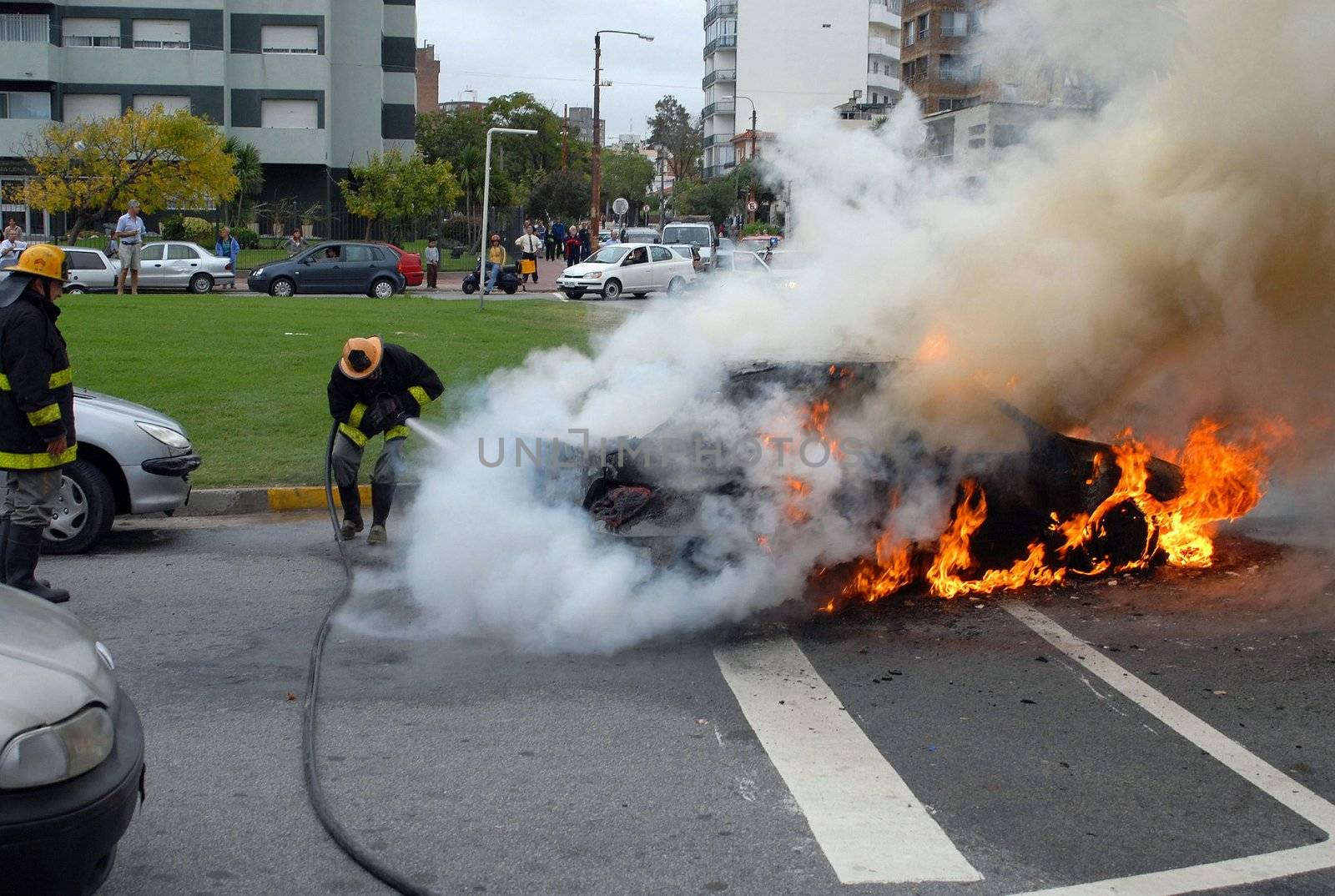 Firefighters extinguishing a car fire. Advanced stage of a fire by cienpies