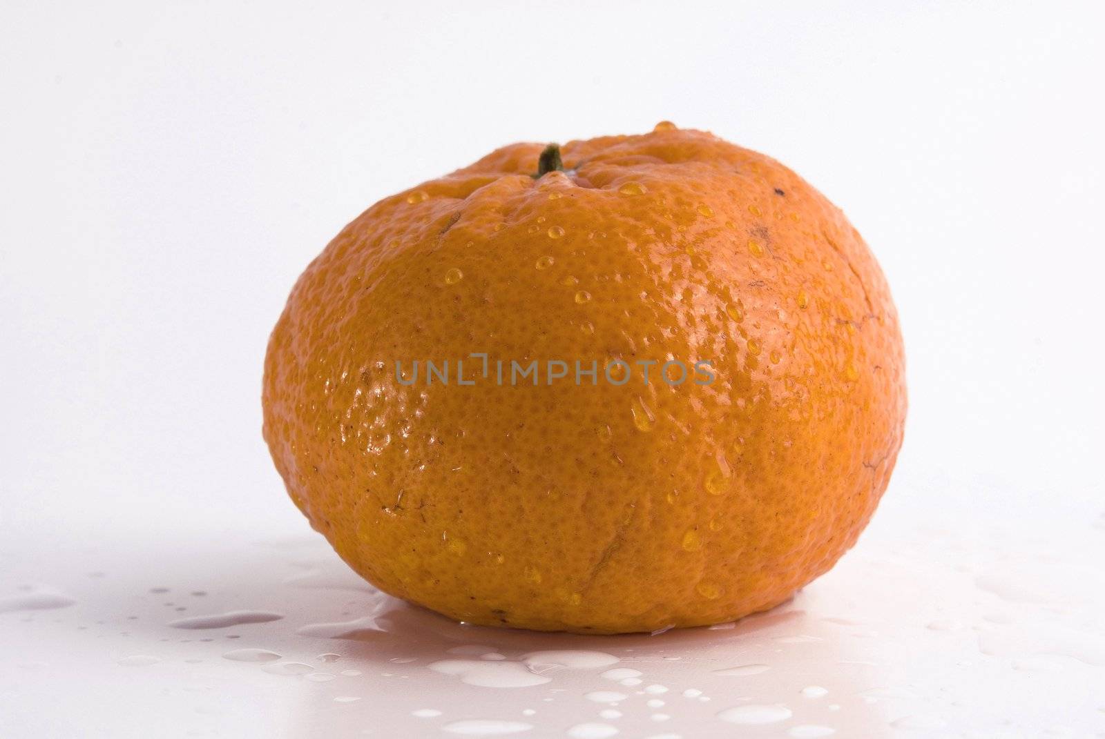 Juicy tangerine covered by drops of water. Isolated on white background
