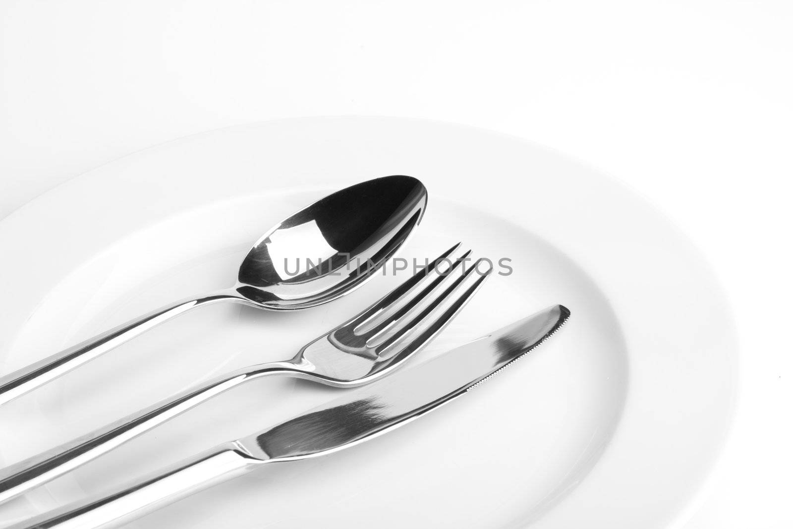 fork, knife, spoon and a white plate by bernjuer