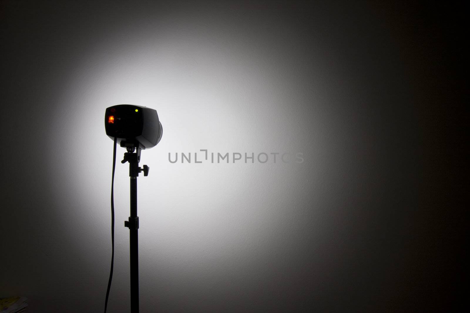 small studio flash throwing a spotlight on the wall by bernjuer