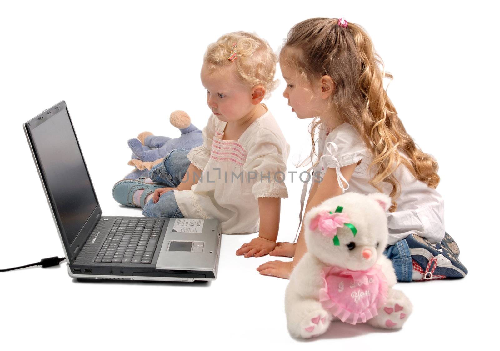 Little girls staring at a notebook computer by cienpies