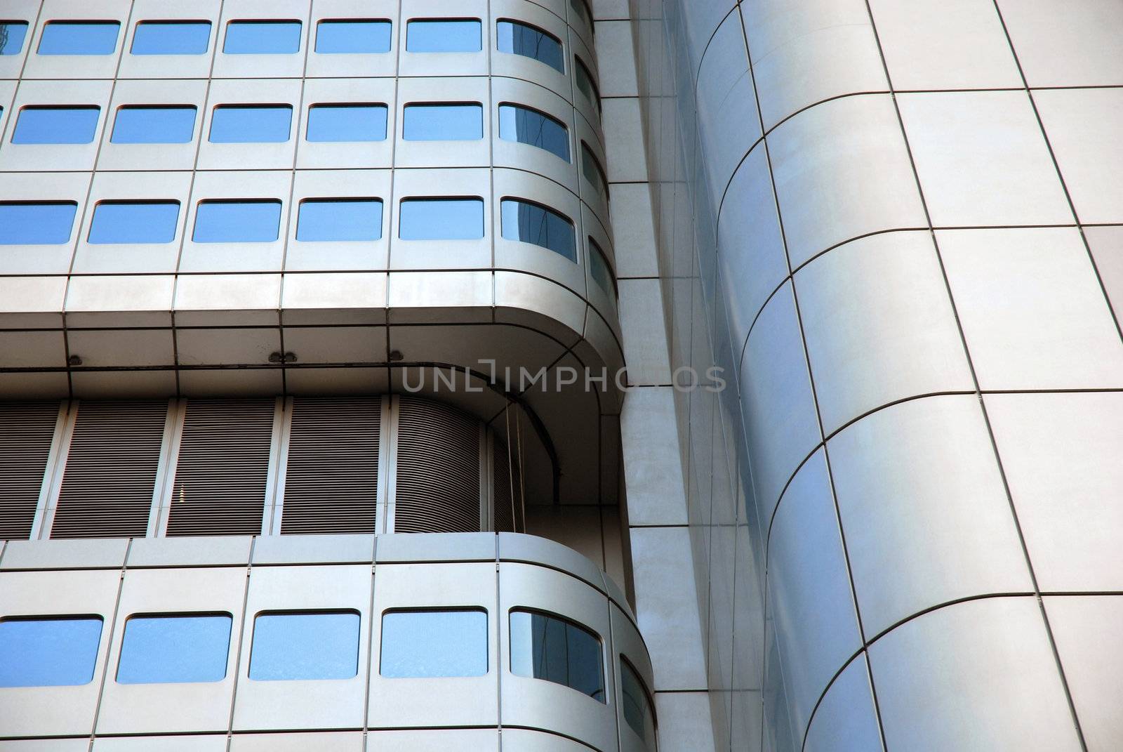 Curved  skyscraper detail reflecting a blue sky.