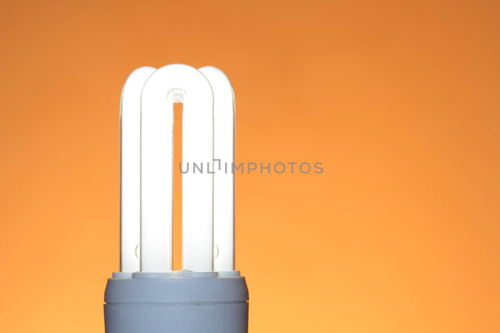 Energy saving compact fluorescent lightbulb isolated on ginger background