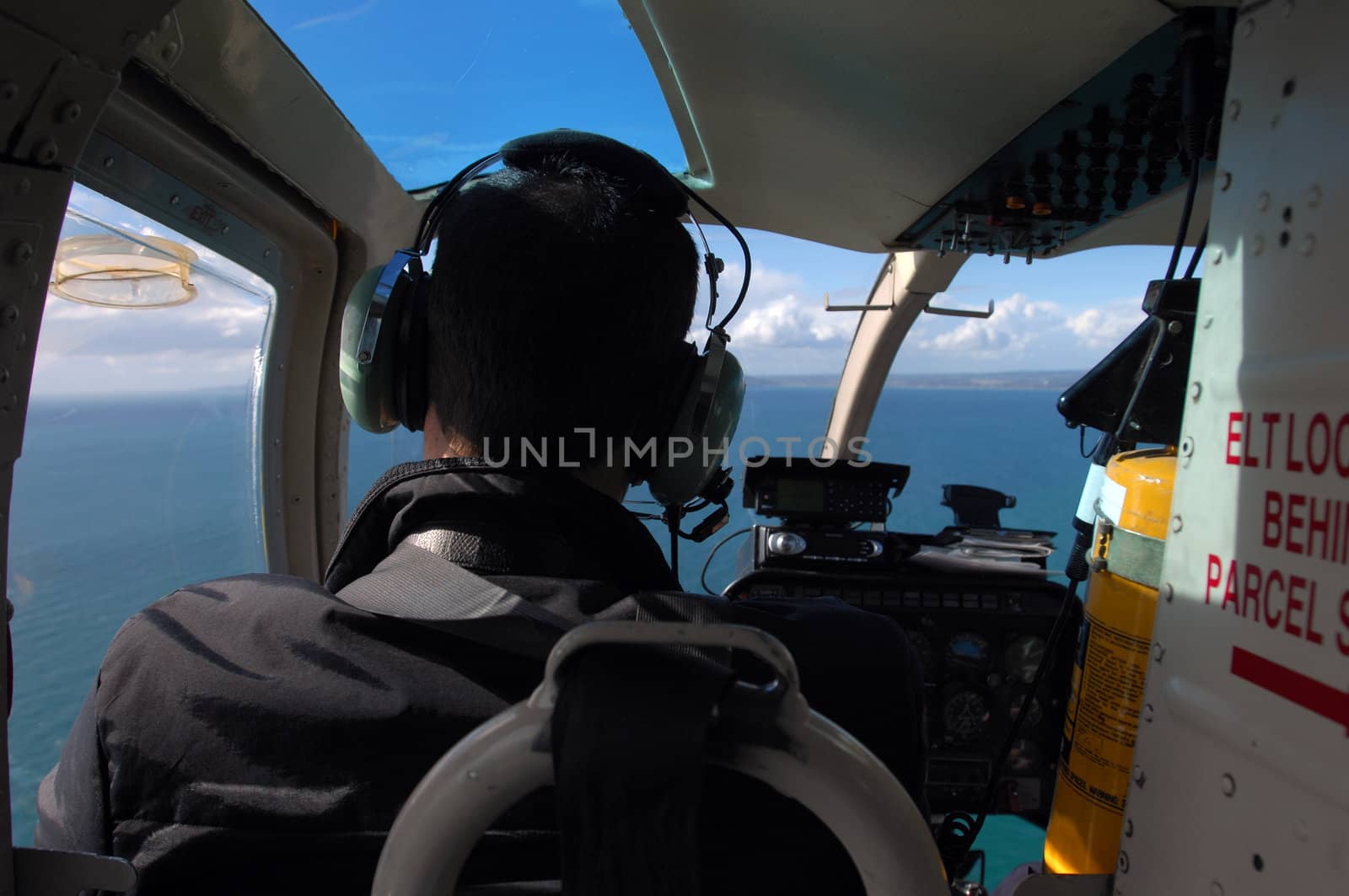 A view from the passenger's seat in a helicopter flying over a body of water