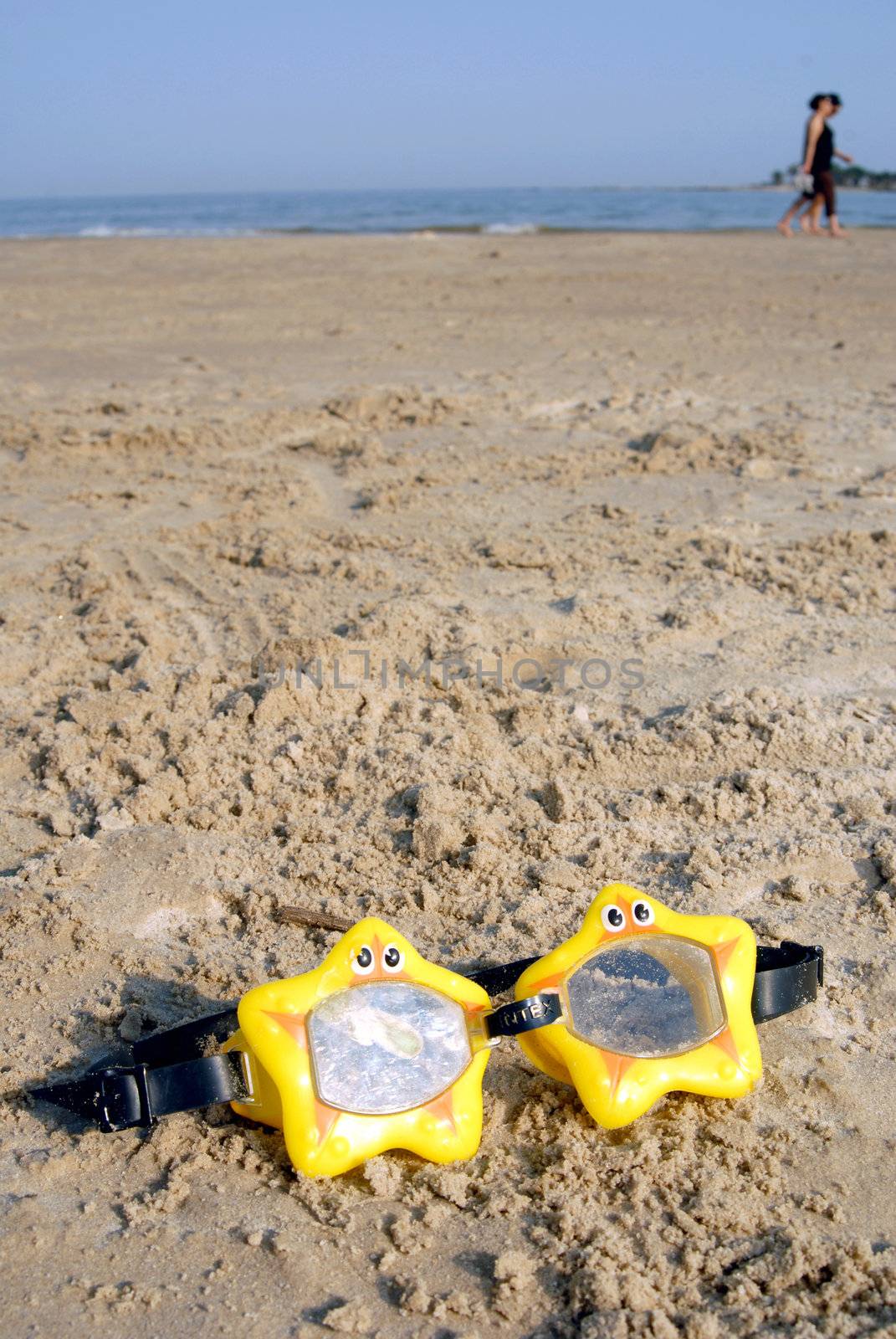Toy swimming glasses on the beach by cienpies