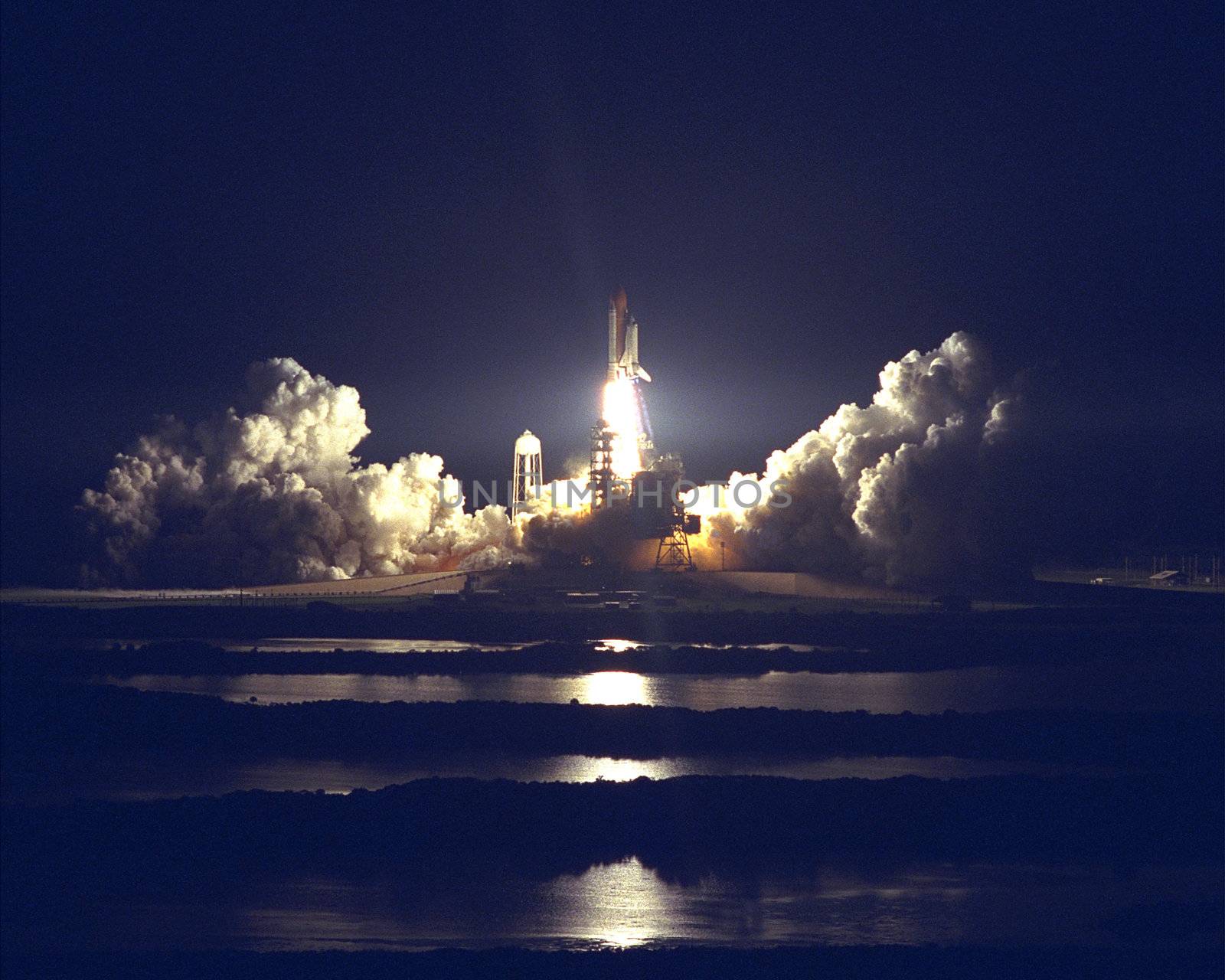 The Space Shuttle Atlantis blazes through the night sky to begin the STS-86 mission, slated to be the seventh of nine planned dockings of the Space Shuttle with the Russian Space Station Mir. Liftoff on September 25 from Launch Pad 39A was at 10:34 p.m. EDT, within seconds of the preferred time, during a six minute, 45 second launch window. The 10 day flight will include the transfer of the sixth U.S. astronaut to live and work aboard the Mir. After the docking, STS-86 Mission Specialist David A. Wolf will become a member of the Mir 24 crew, replacing astronaut C. Michael Foale, who will return to Earth aboard Atlantis with the remainder of the STS-86 crew. Photo taken: 09/25/1997. ** Credit: NASA / yamicro.com **