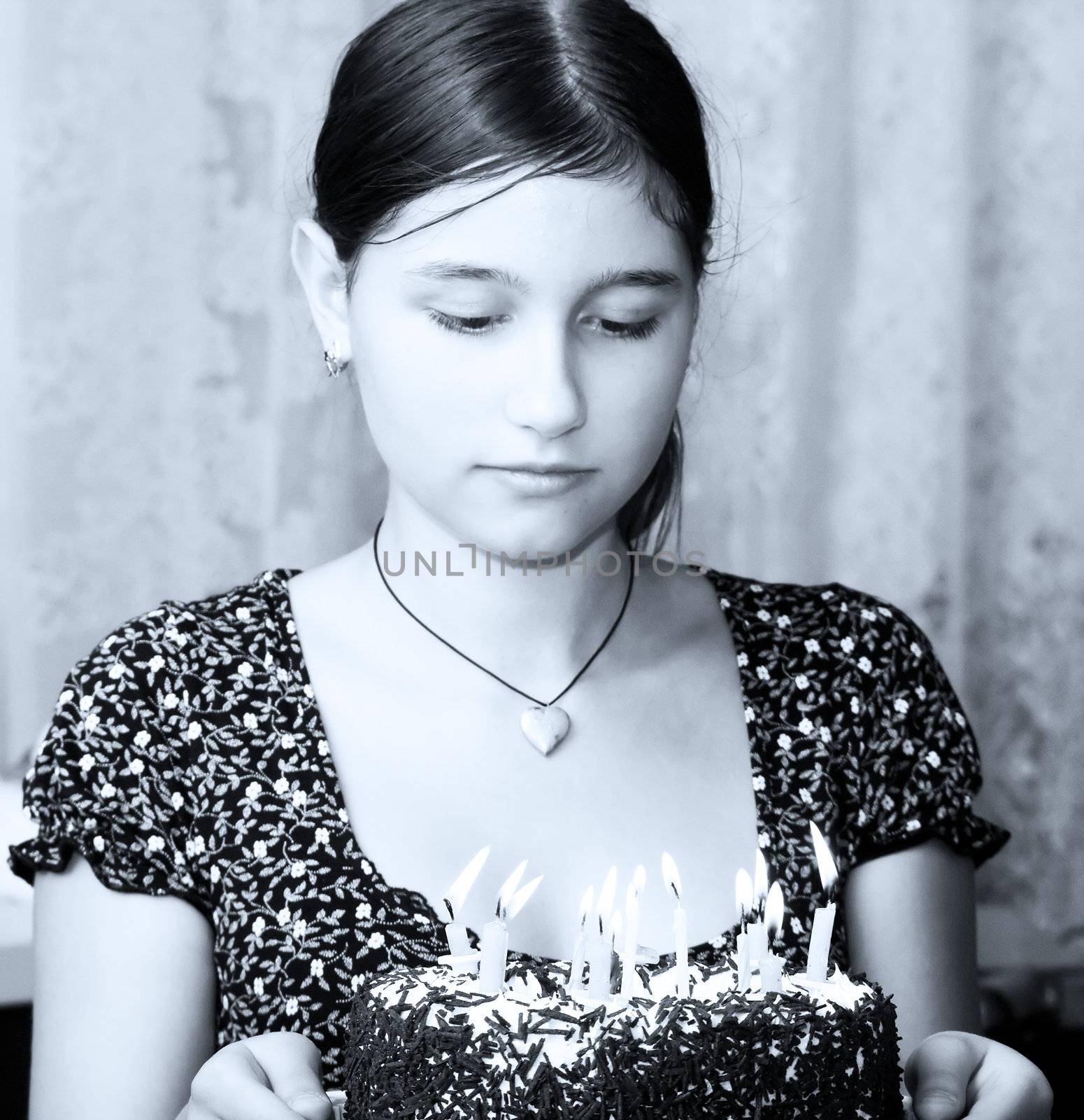 The happy girl holds in hands a celebratory cake with candles