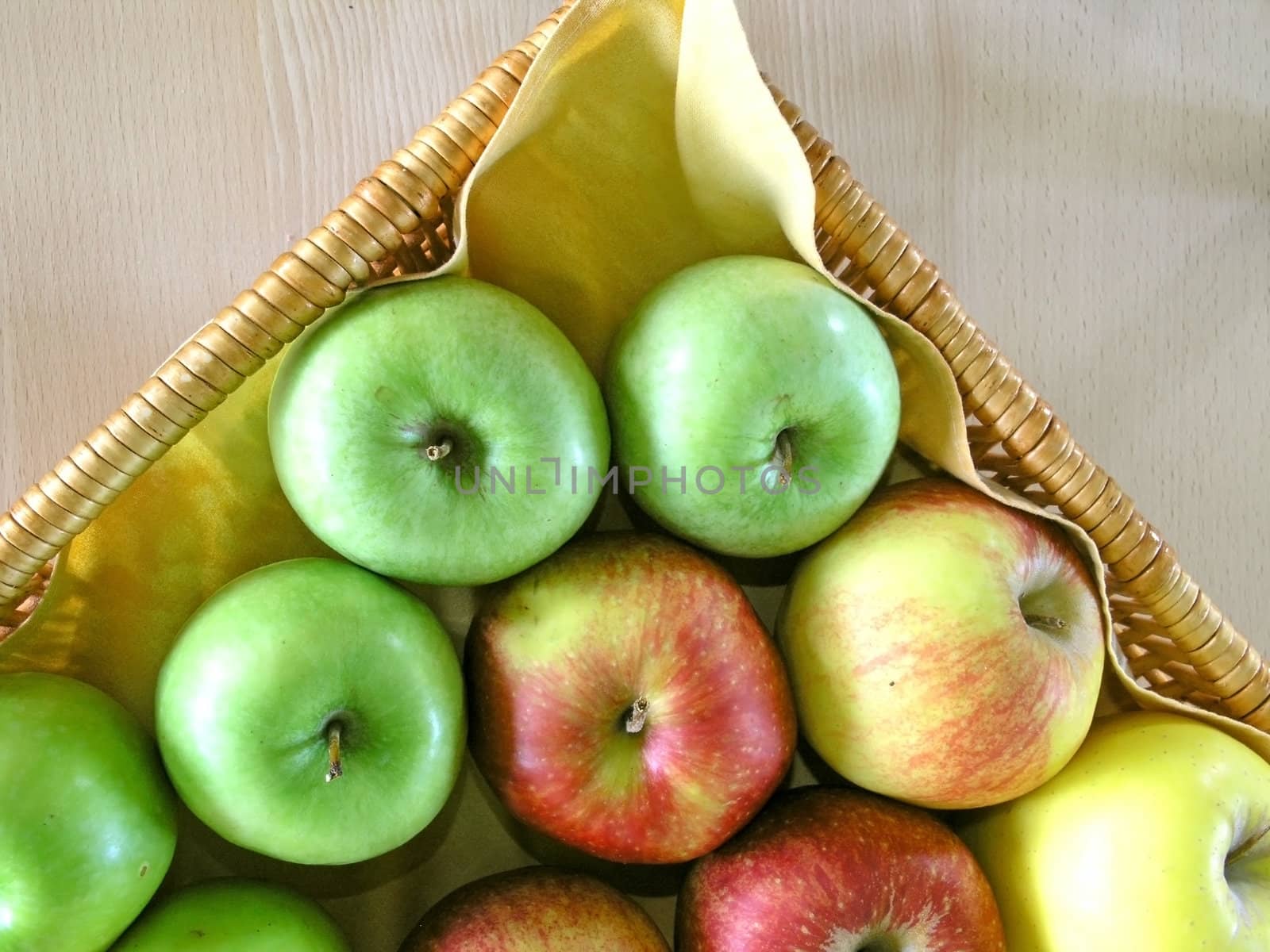 red, green  and yellow apples in basket