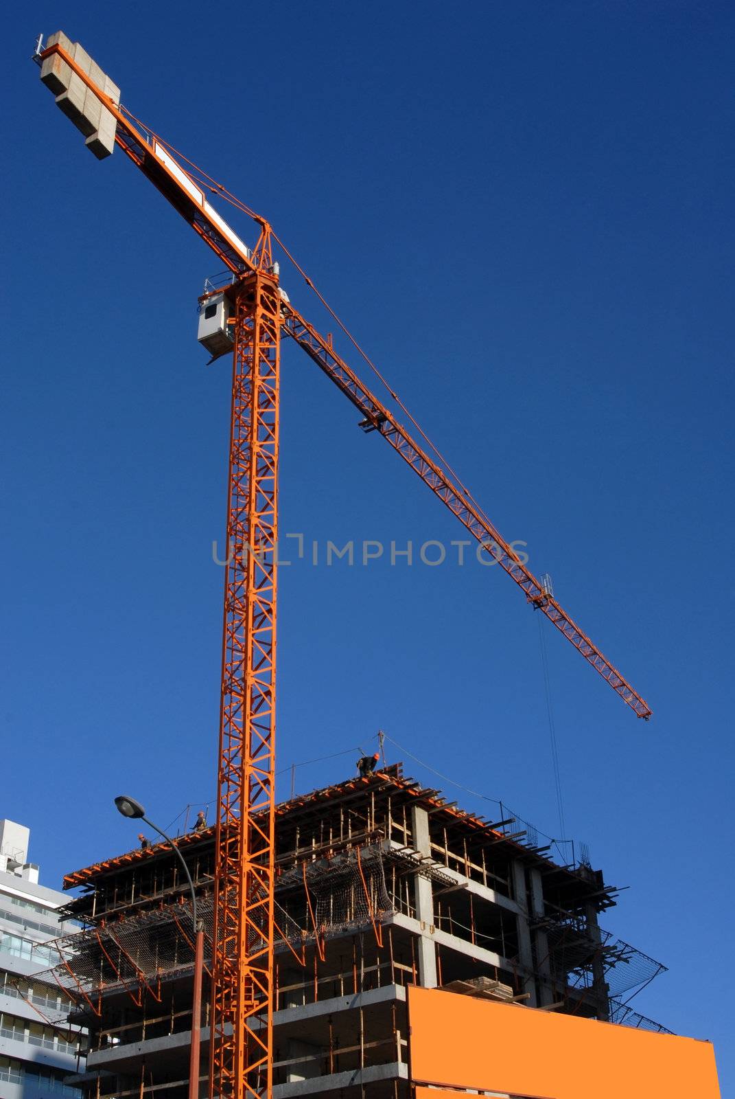 Crane at a building construction. Blue sky background