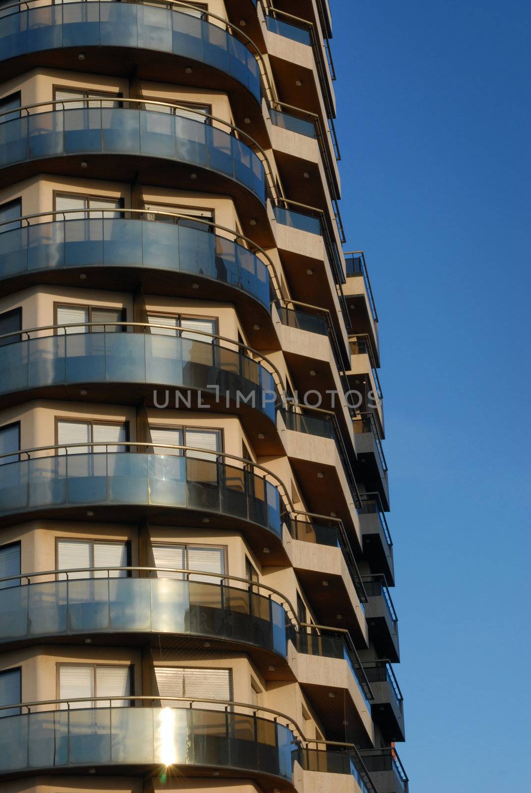Modern building with balcony on a blue sky background
