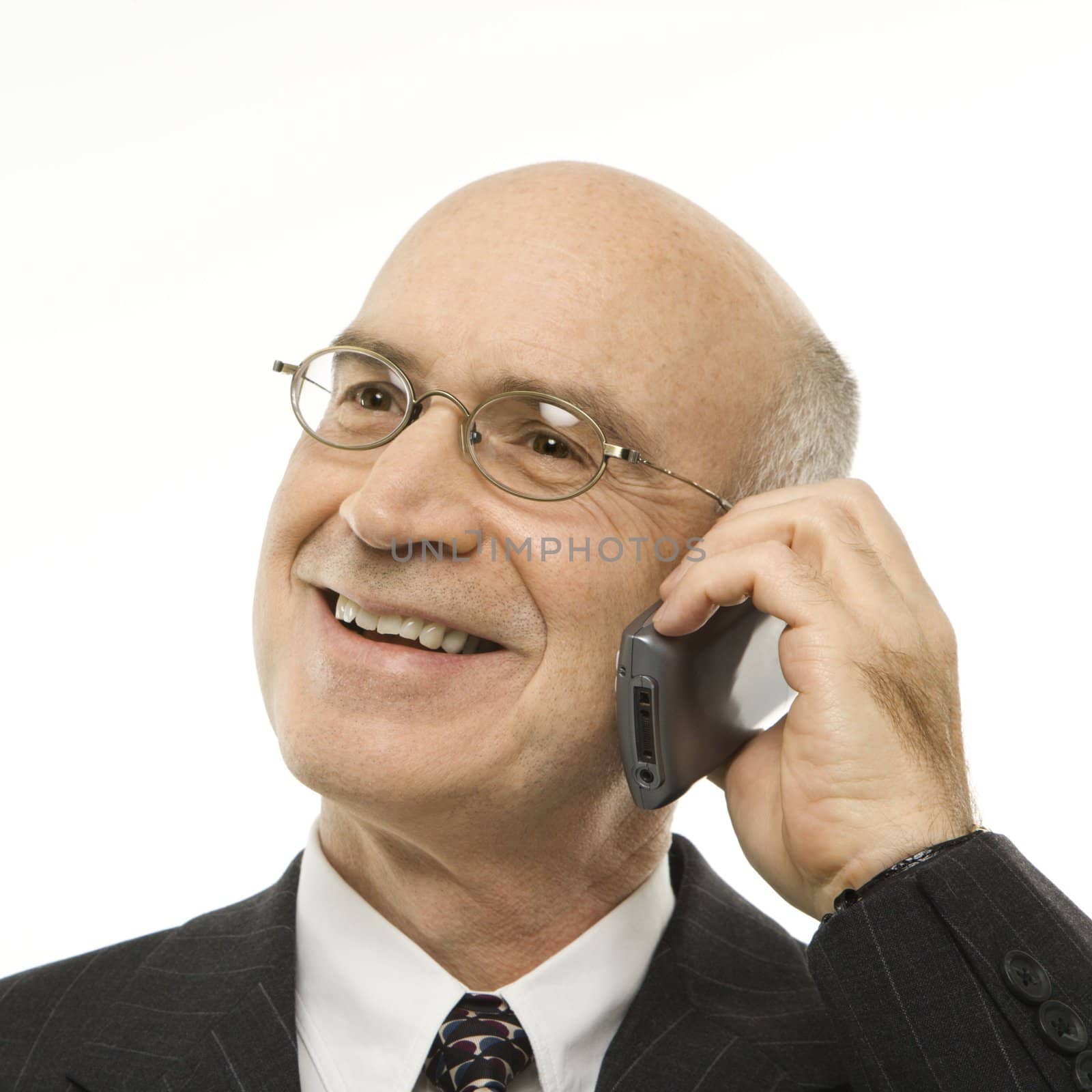 Caucasian middle-aged businessman talking on cellphone smiling against white background.