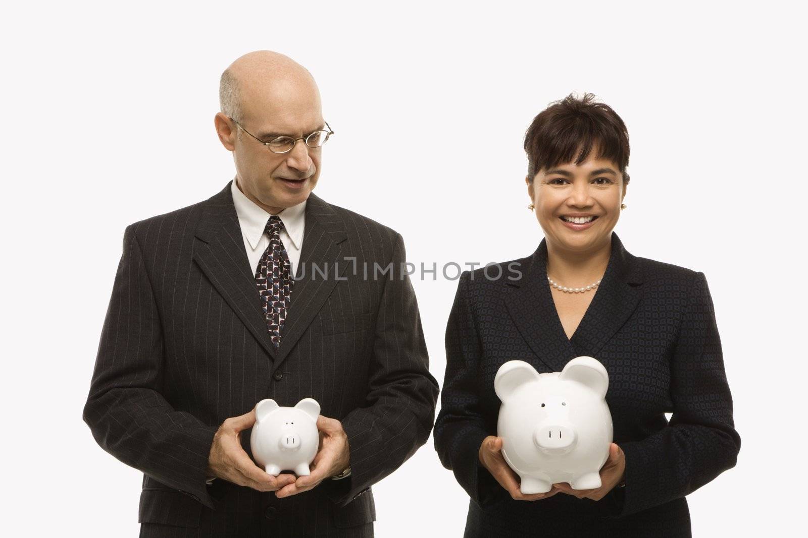 Caucasian middle-aged businessman and Filipino businesswoman holding different sized piggybanks.