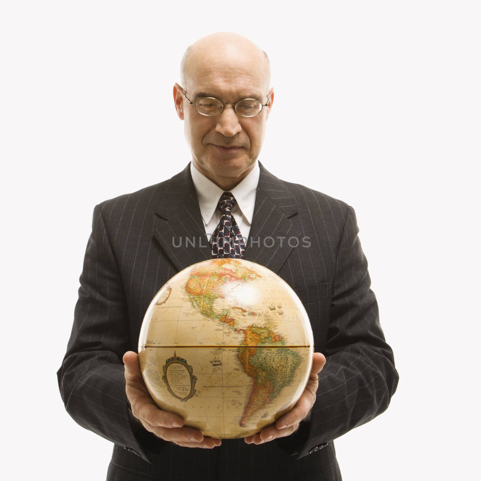 Caucasian middle-aged businessman holding globe in both hands standing in front of white background.