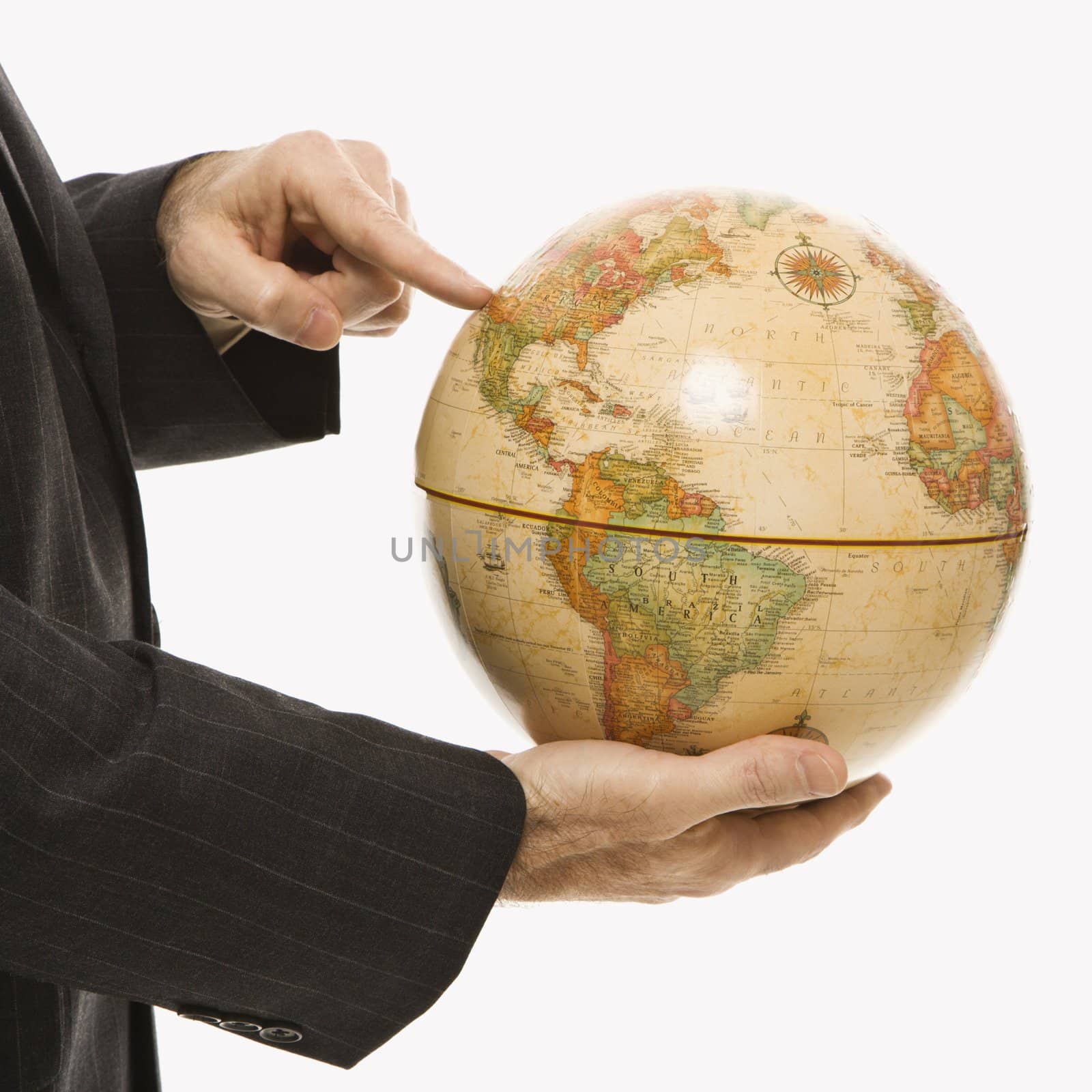 Caucasian middle-aged businessman holding globe and pointing standing in front of white background.