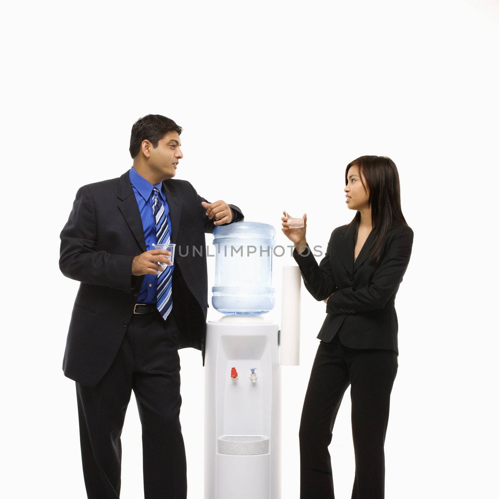 Vietnamese businesswoman and Indian businessman conversing at water cooler.