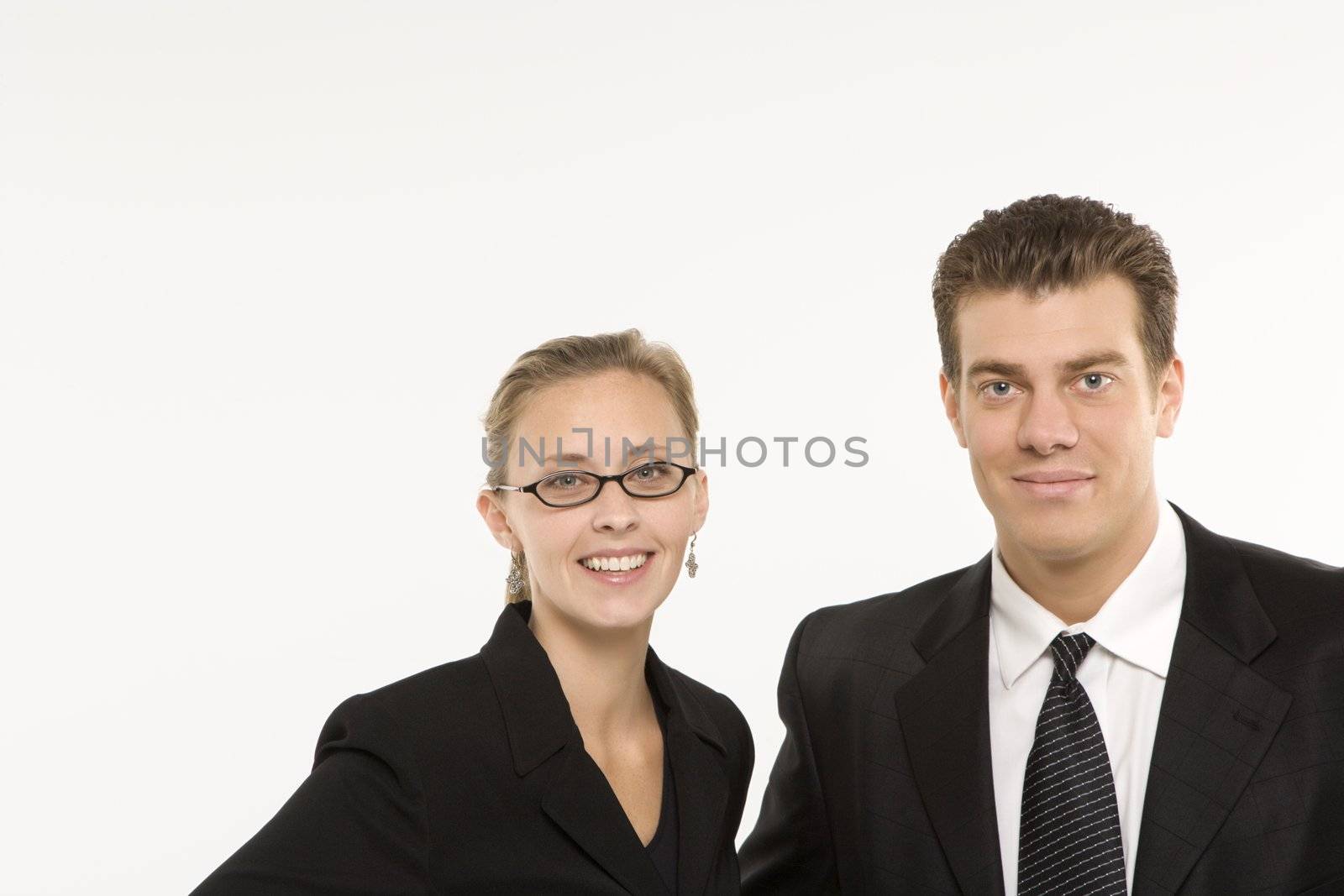 Portrait of Caucasian mid-adult businessman and woman smiling and looking at viewer.