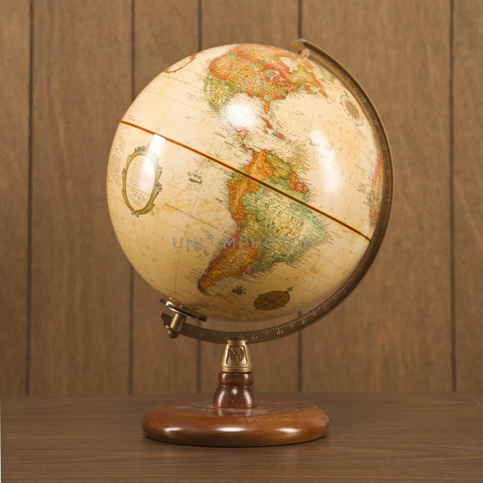 Sill life shot of a vintage world globe sitting on a desk.