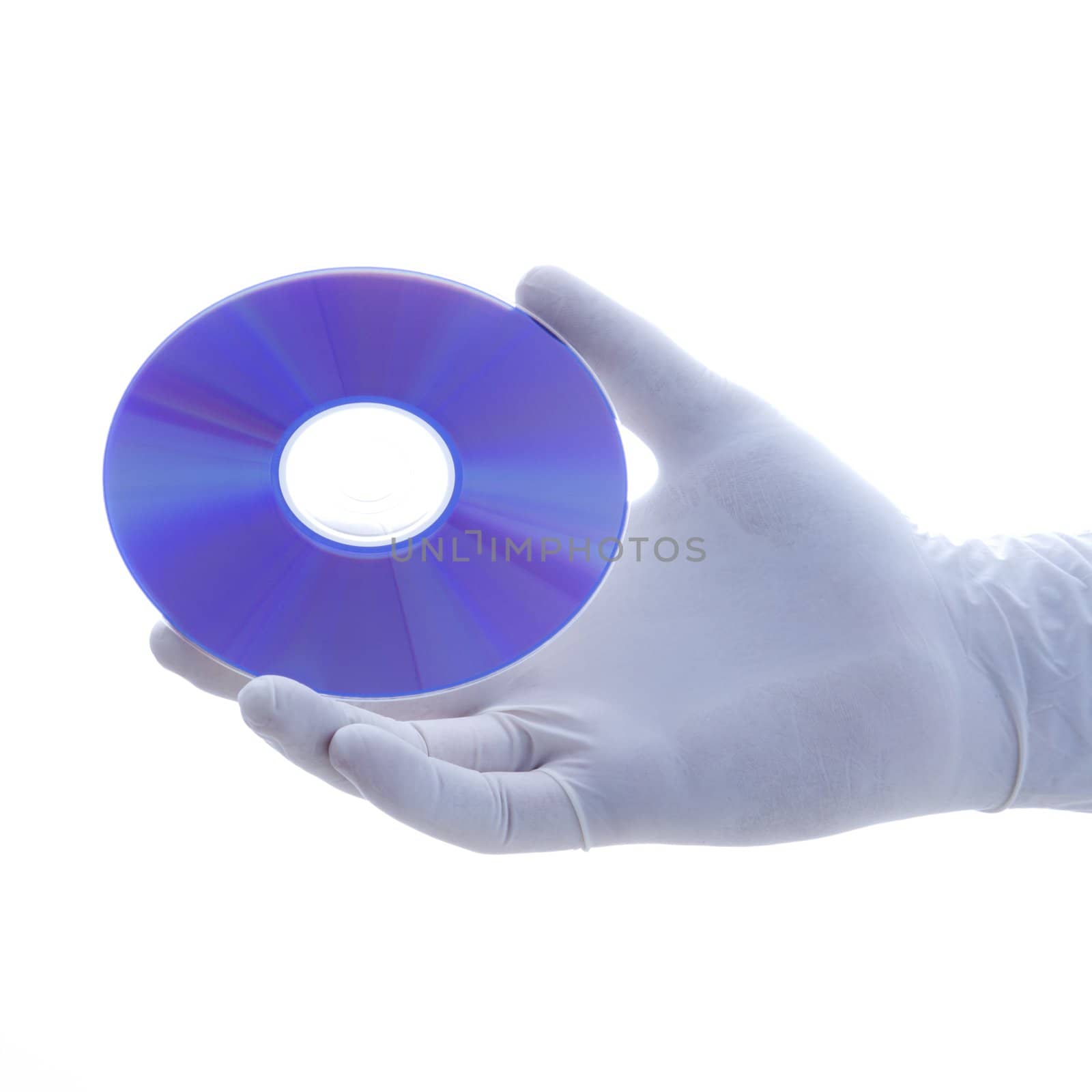 Hand in latex glove holding disc against white background.