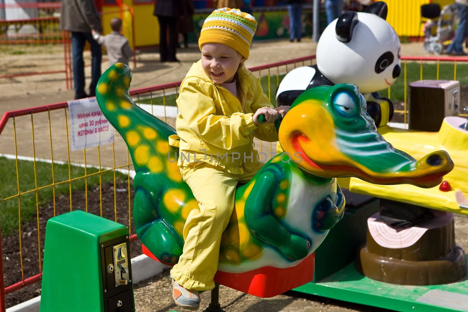 The daughter goes for a drive on the crocodile in park of entertainments