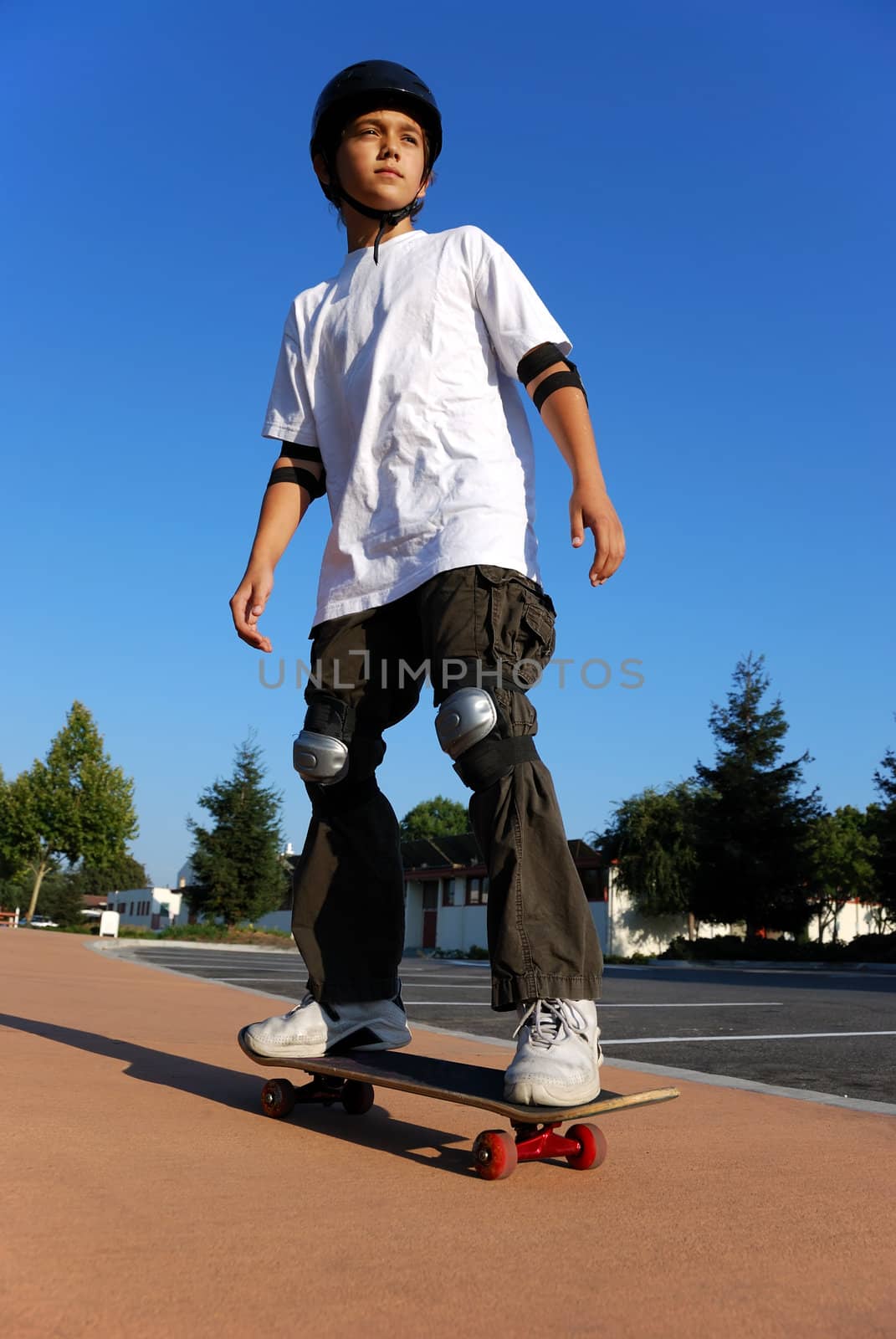 Boy on a Skateboard Against Blue Sky Looking in the Sun