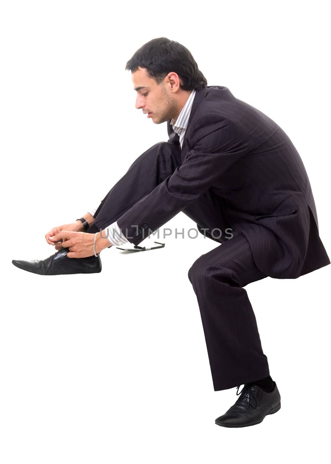 Shoe lacing. Serious businessman sitting against isolated white background