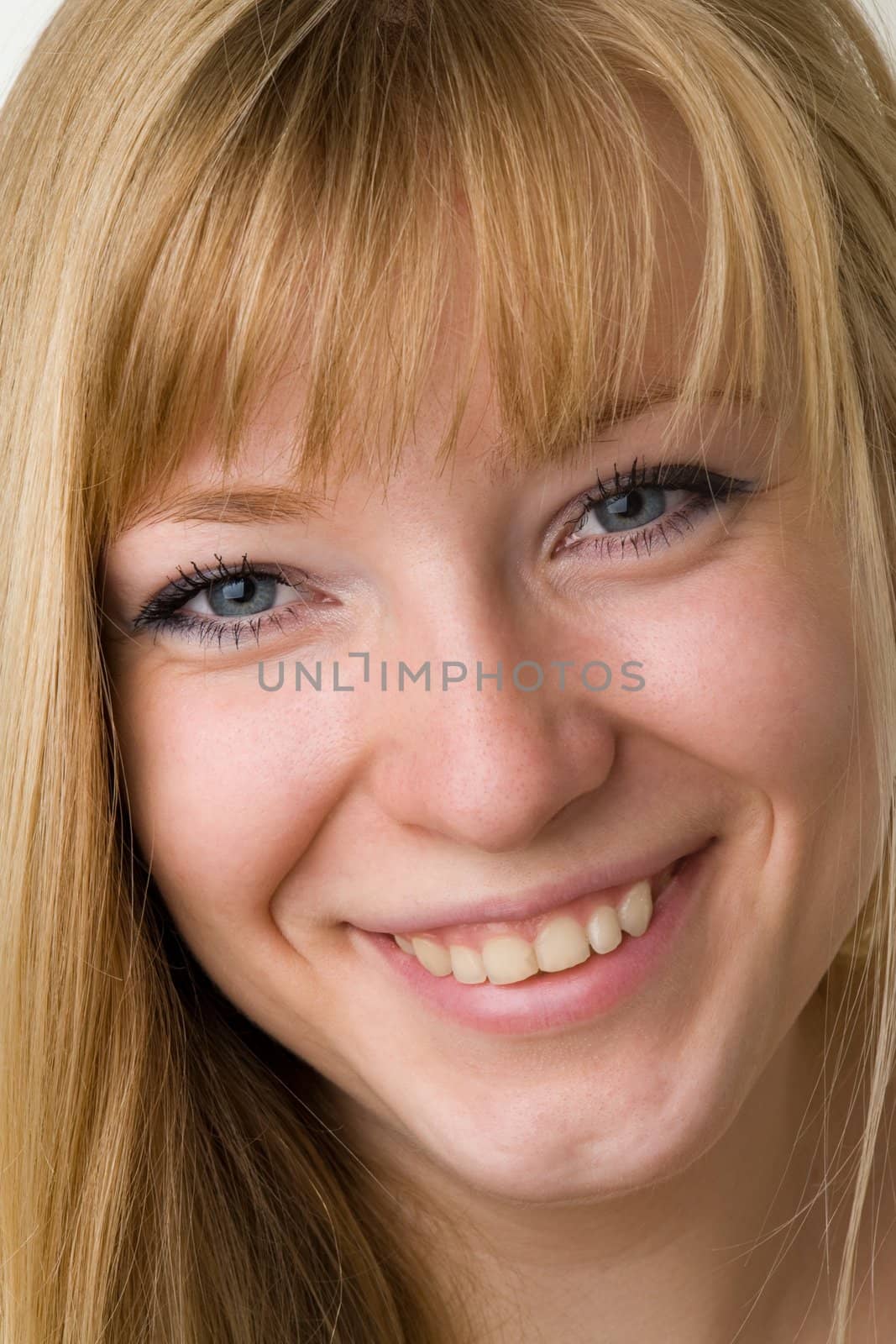 Portrait of the smiling young woman. The beautiful face close up.