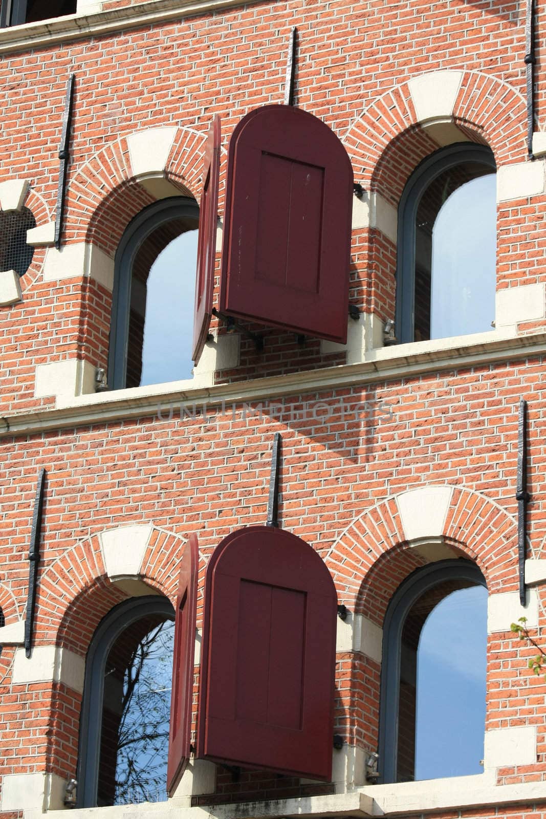 A historic facade in Haarlem, windows with red shutters