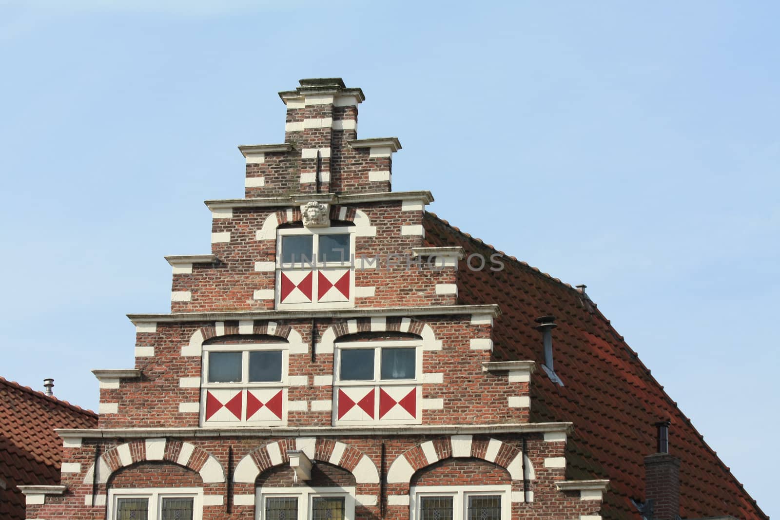 Windows with shutters in a traditional pattern on a classic crow stepped gable