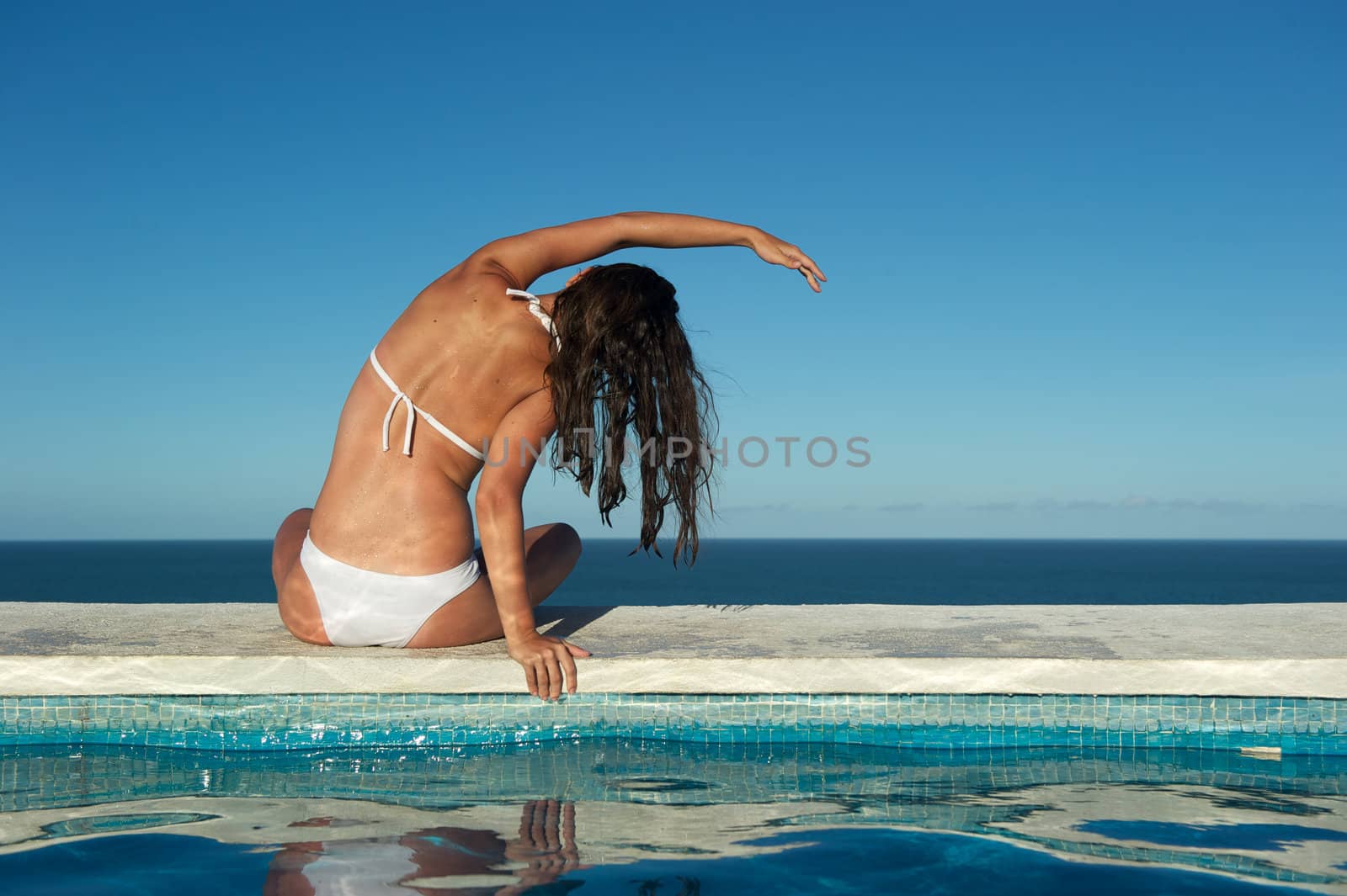 Woman relaxing on a swimming pool with a sea view in Arraial d'Ajuda, Bahia, Brazil, Nikon D3S, RAW shooting.