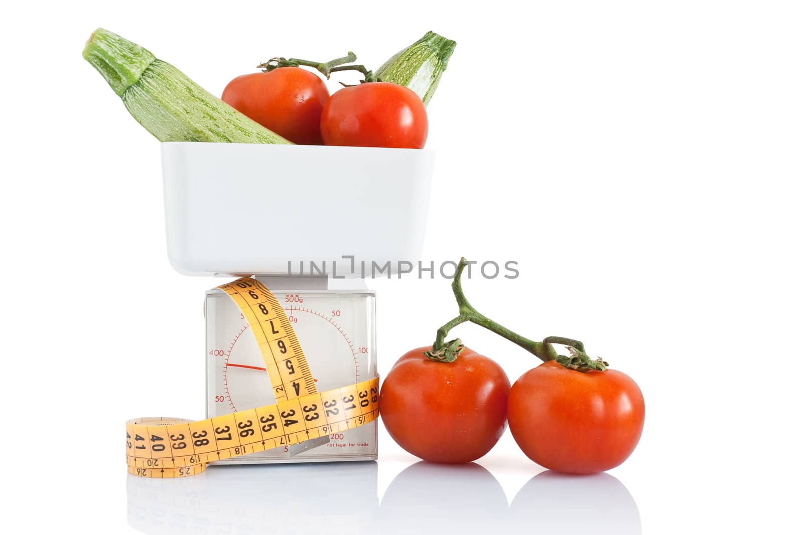 vegetables on kitchen scale with tape meter isolated on white background with clipping path
