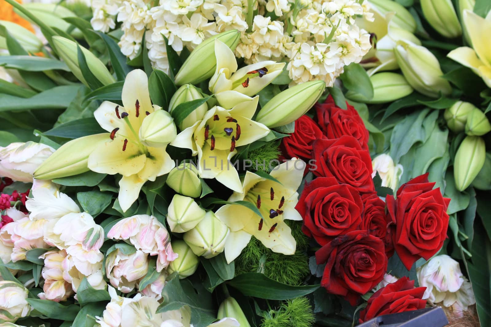 red roses and white lilies in a floral arrangement