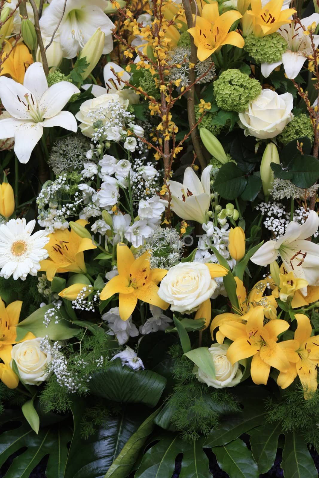 yellow and white flower arrangement with lilies