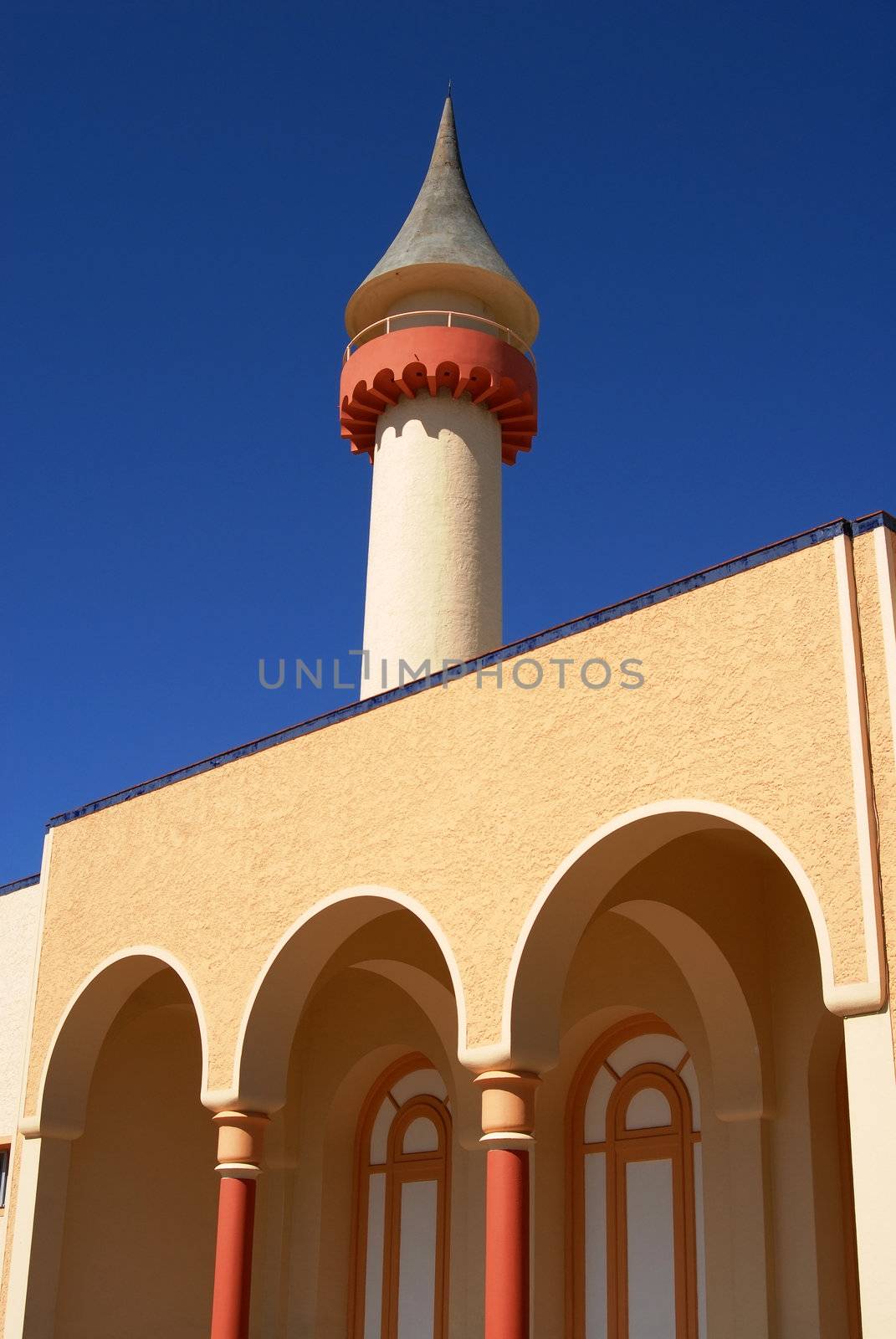 Landmark building detail. Tower and arcades on blue sky background