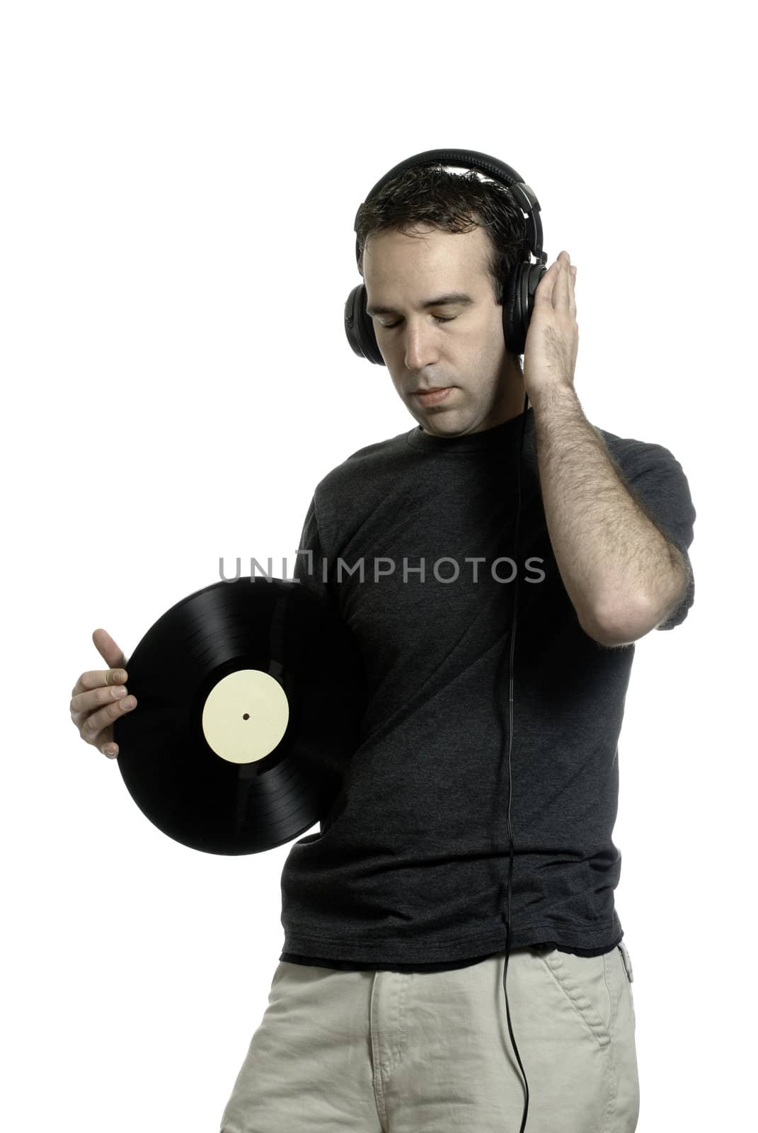 A young man wearing a set of headphones and holding an old LP record, isolated against a white background