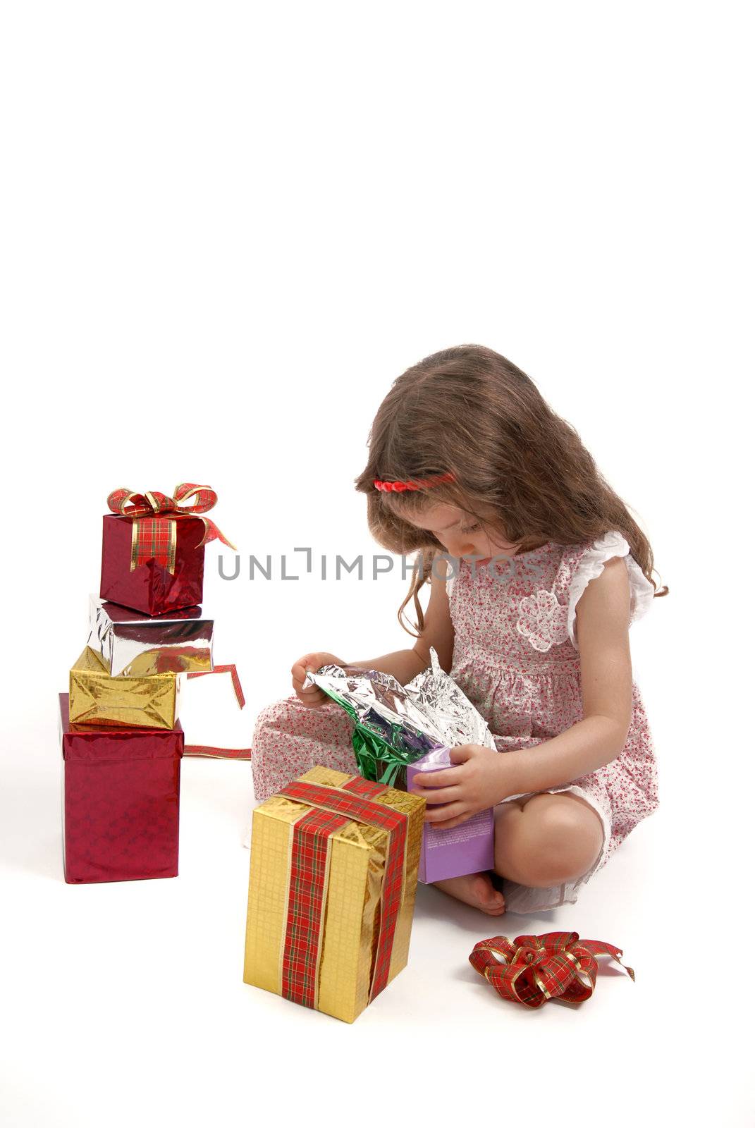 Little girl opening her Christmas presents. White background