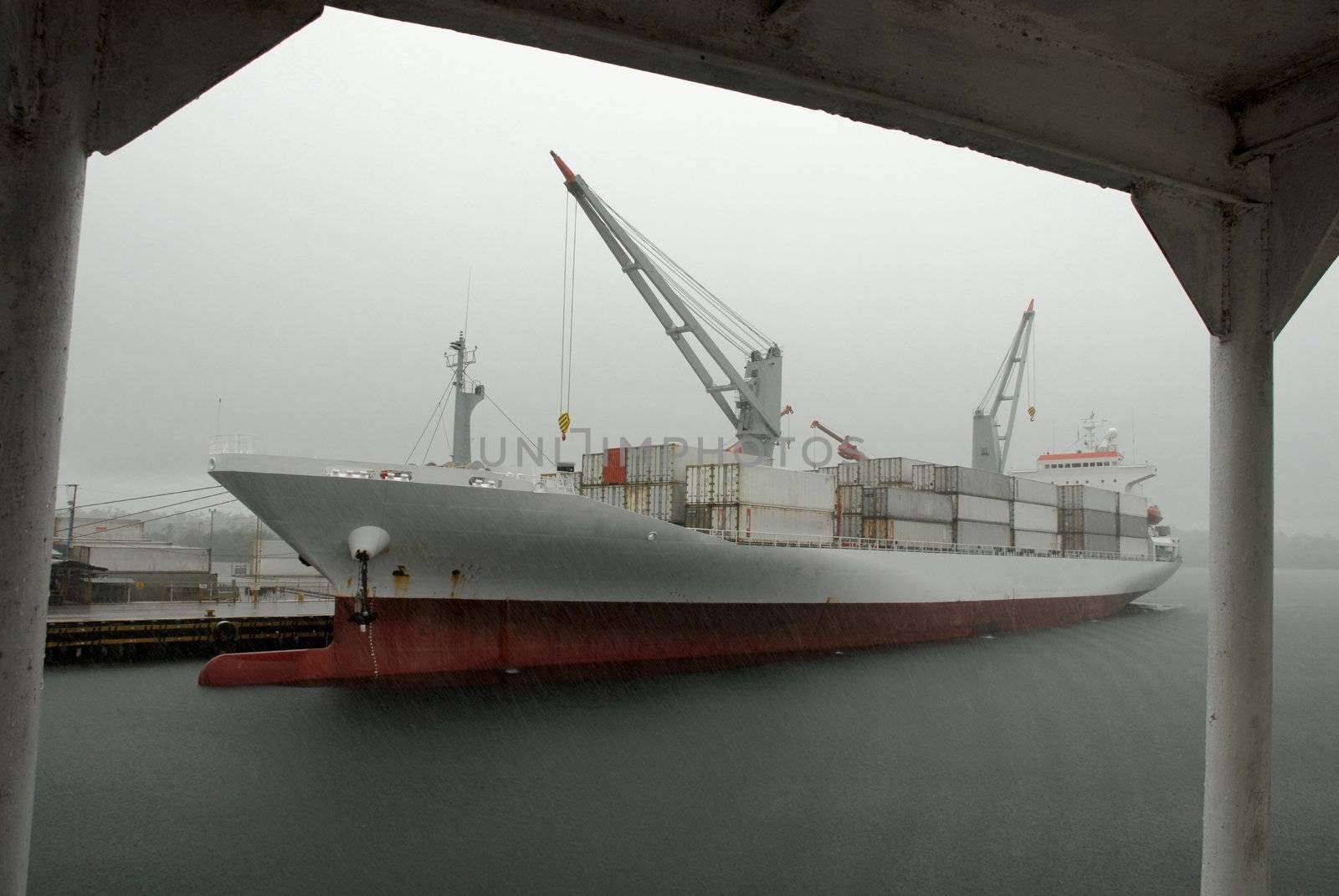 Huge container cargo ship heading for port. Cloudy sky background