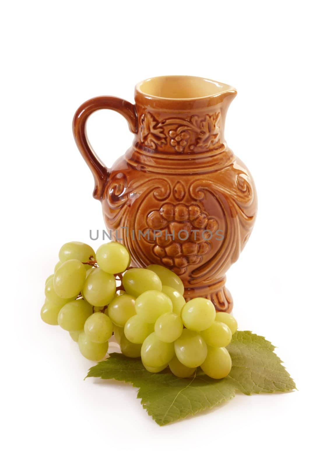 Brown wine jug with grapes on white background